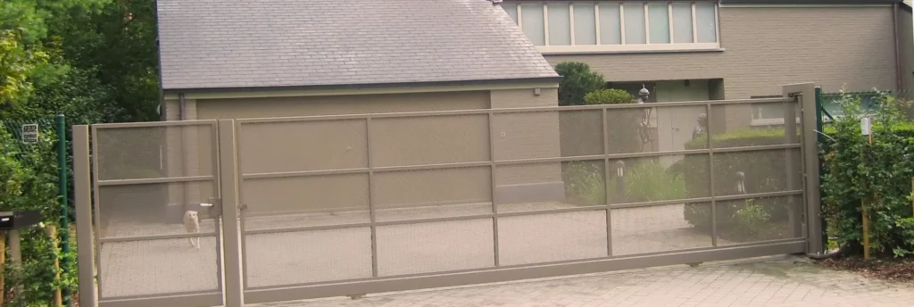 Schuifpoort met geperforeerde stalen panelen voor een woning