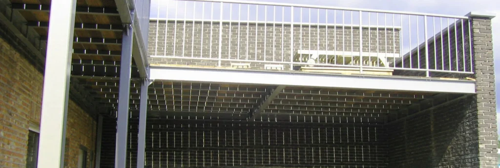 Stalen draagstructuur onder een terras met balustrade