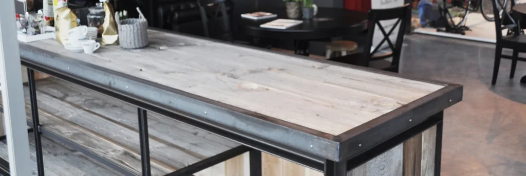 Lange tafel met stalen frame en een verweerd houten blad