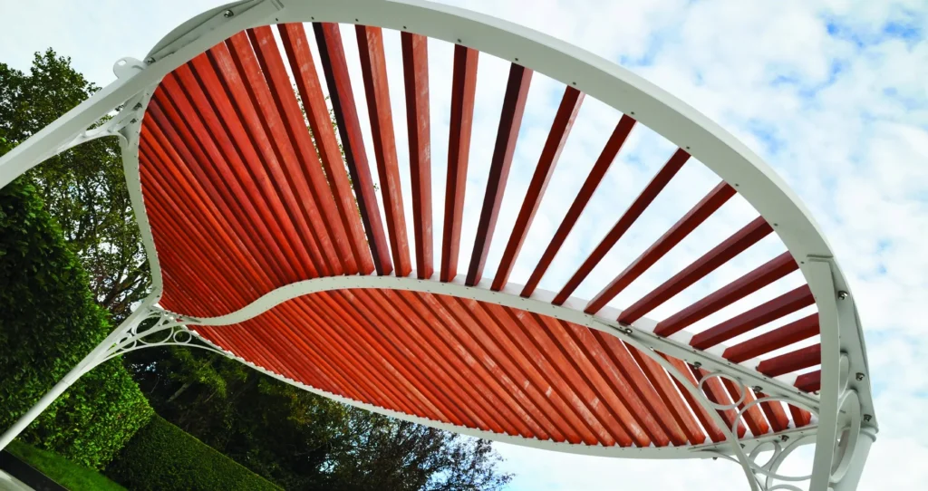 Witte stalen pergola met gebogen houten latten